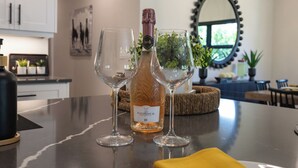 A bar area with a bottle of Fleurs de Lune wine, two glasses, and a yellow napkin on a marble countertop.