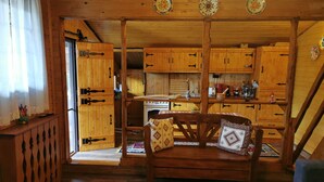 A cozy cabin interior with wooden walls and a dining area. - Casuta cu Brazi (Seusa)