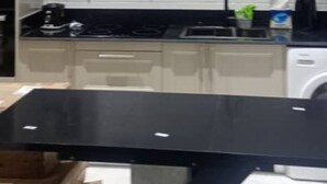 A modern kitchen with white cabinets, a black countertop, and a built-in stove. - Elite Arlington Court Apartment - East Legon (East Legon, Accra)