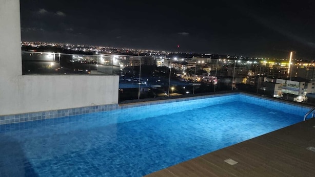 A rooftop pool with a city view at night. - Elite Arlington Court Apartment - East Legon (East Legon, Accra)