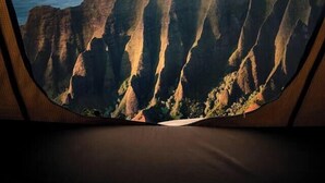 Vista desde una ventana: acantilados escarpados y una masa de agua.