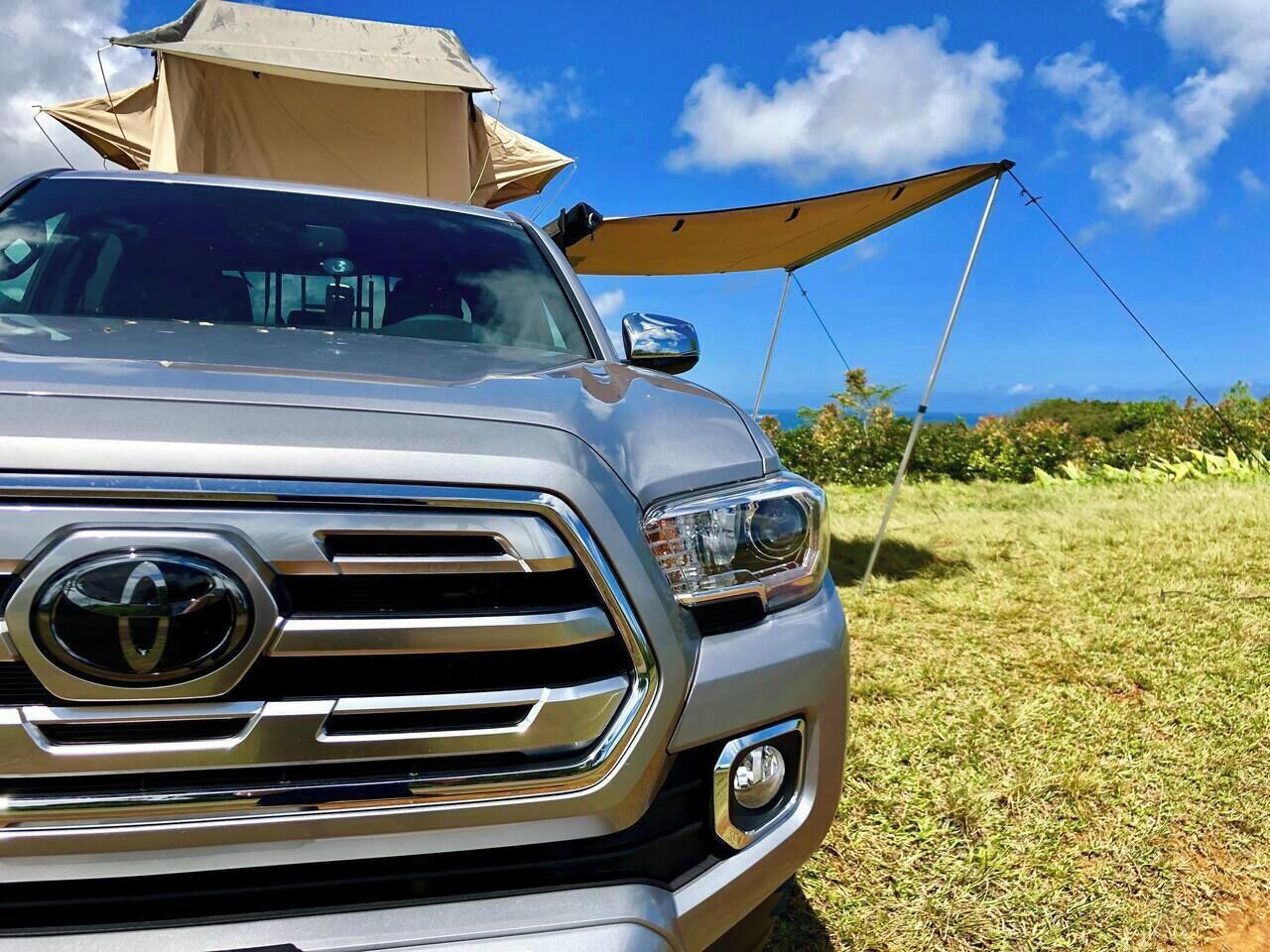 Ein Fahrzeug mit Campingausrüstung, darunter ein Zelt und ein Vorzelt.