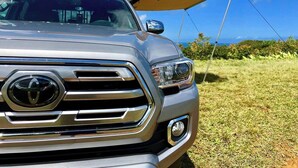 A vehicle with a camping setup, including a tent and a canopy. - Silver Fox Camper 2018 Tacoma (Anahola)