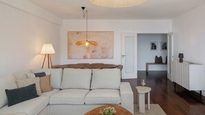Ein modernes Wohnzimmer mit einer Couch, einem Couchtisch, einer Lampe und einer Pendelleuchte.
