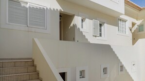 Un immeuble à plusieurs étages, doté d’un escalier, de nombreuses fenêtres et d’un sol carrelé.