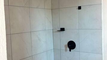 Habitación individual básica | Baño | Regadera, toallas, jabón, shampoo