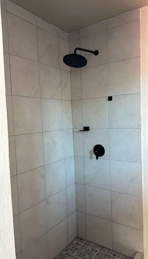 Habitación individual básica | Baño | Regadera, toallas, jabón, shampoo