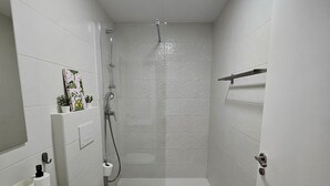 A modern bathroom with a shower, toilet, and sink. - Chic Escape Apartment (Godella)