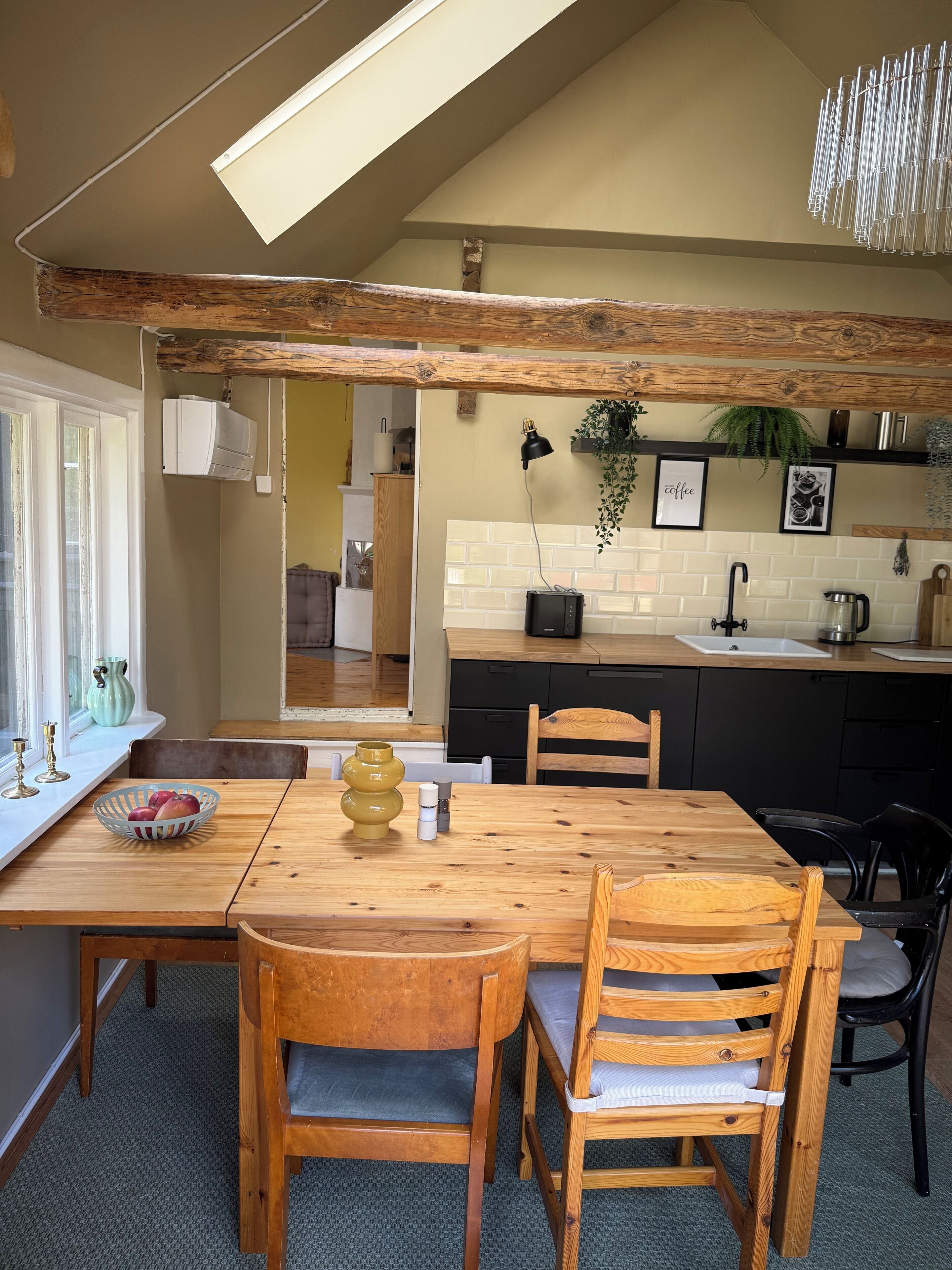 Une cuisine chaleureuse avec une table à manger en bois, des chaises et un revêtement mural moderne.