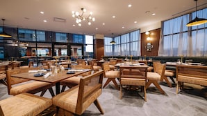 Un restaurant espaiós amb sostres alts, il·luminació moderna i grans finestres.