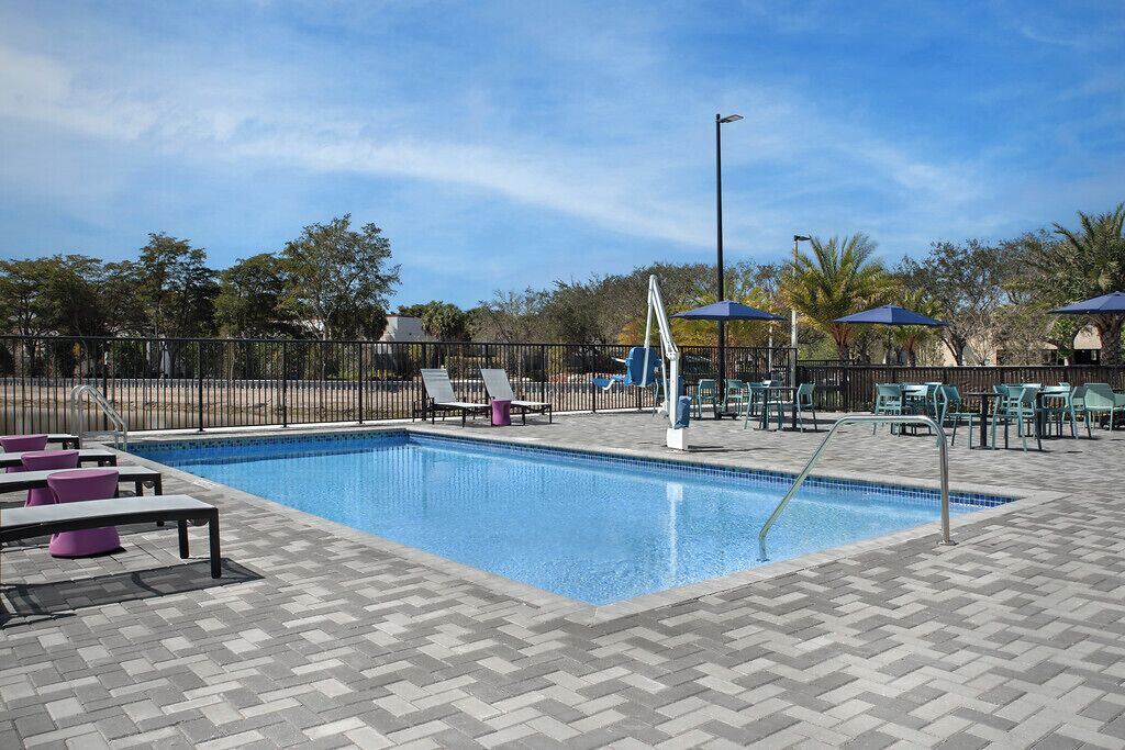 室外游泳池，開放時間為 06:00 至 22:00，提供泳池遮陽傘和日光浴躺椅