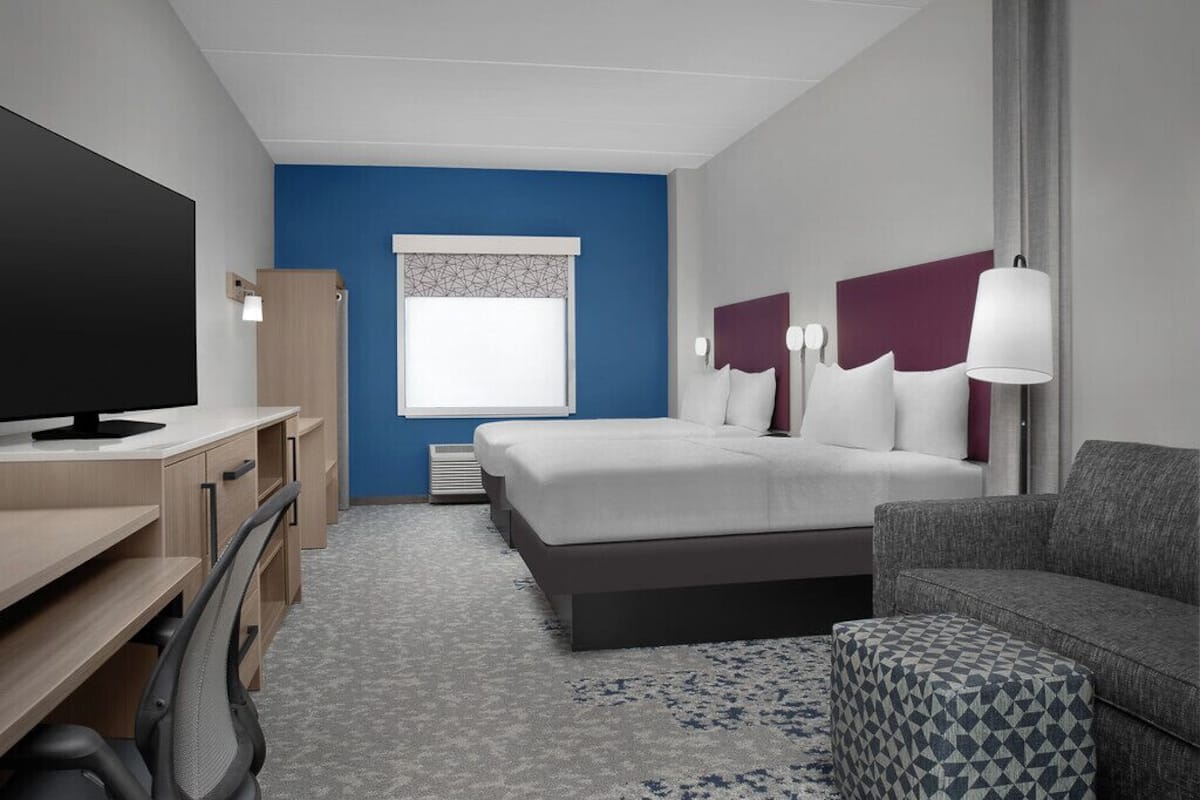 Ropa de cama hipoalergénica y caja de seguridad en la habitación