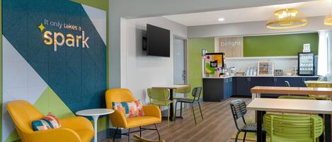 A modern interior with a kitchen area, dining space, and seating with a motivational wall.