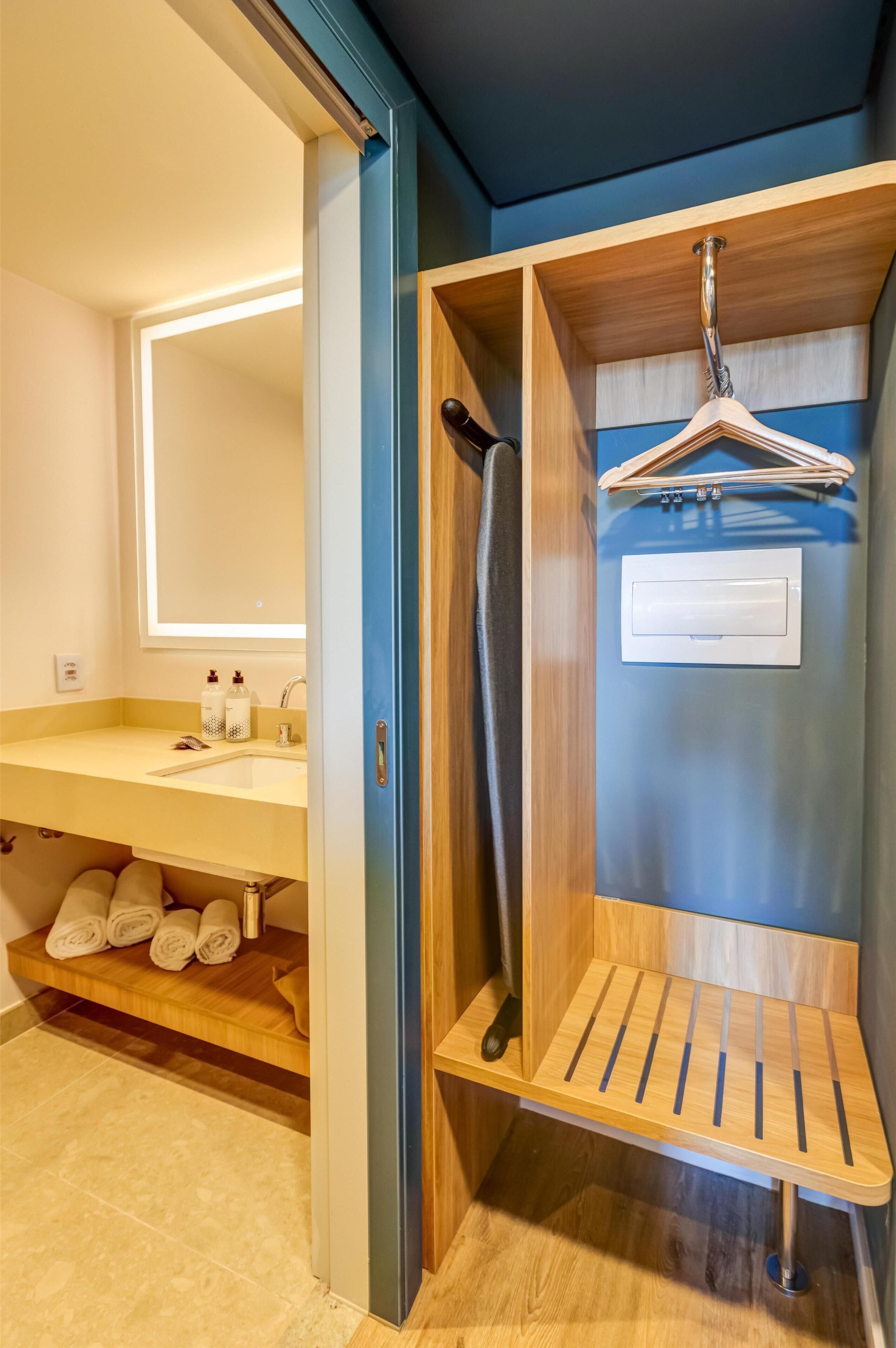 A bathroom with a sink, mirror, and towel rack.