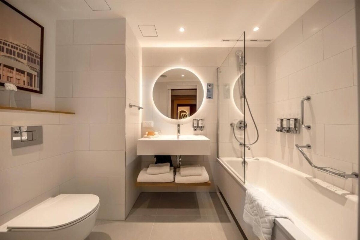 A modern bathroom with a toilet, sink, and bathtub.