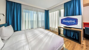 Une chambre d’hôtel équipée d’un lit, d’un téléviseur à écran plat, d’un bureau et d’une chaise.