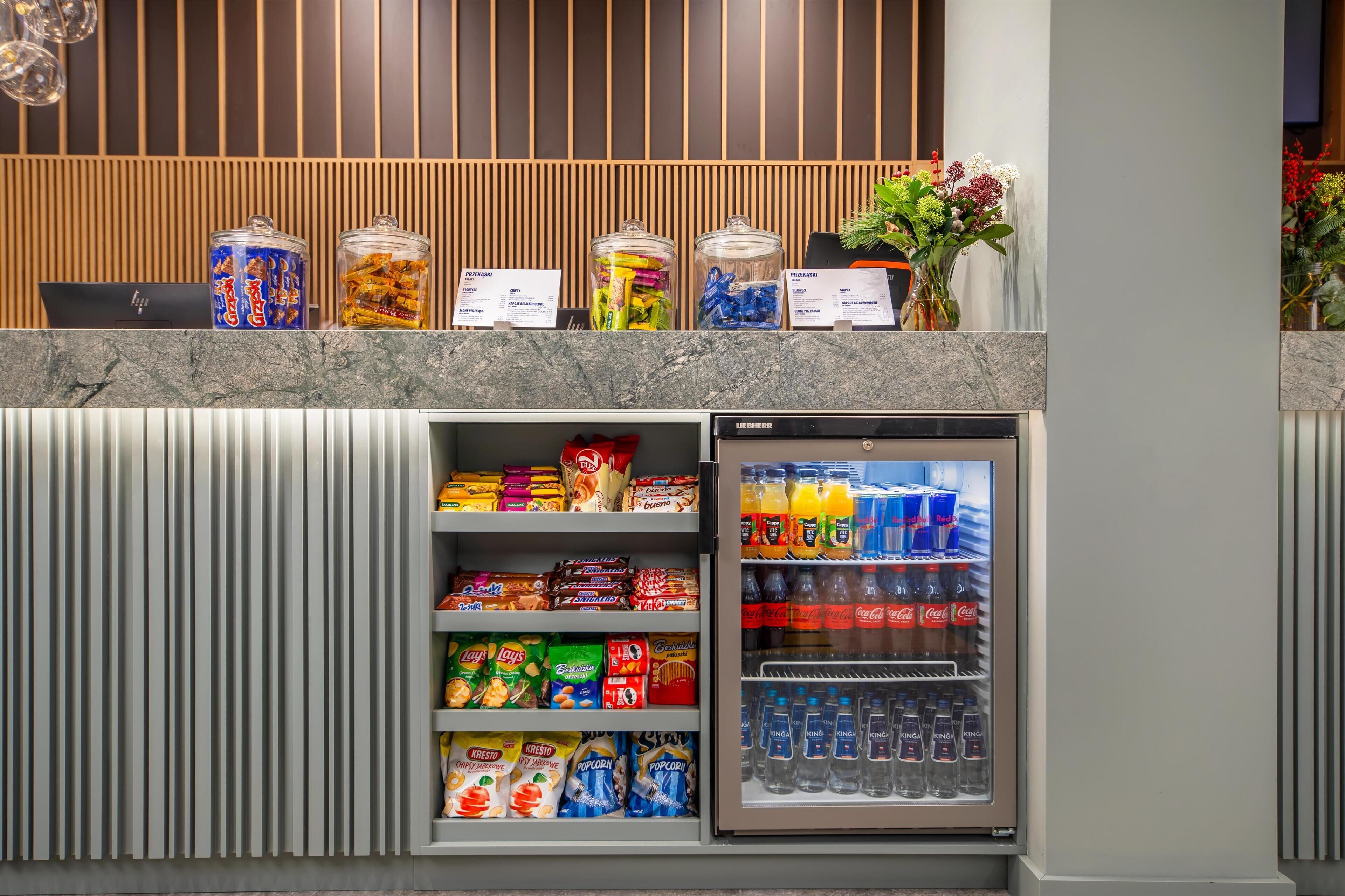 A vending machine stocked with snacks and beverages, including popcorn and soda.