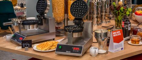 Una estación de waffles con dos máquinas para hacer waffles y un letrero que dice 'NOWE GORY: WINTER SPICE'.