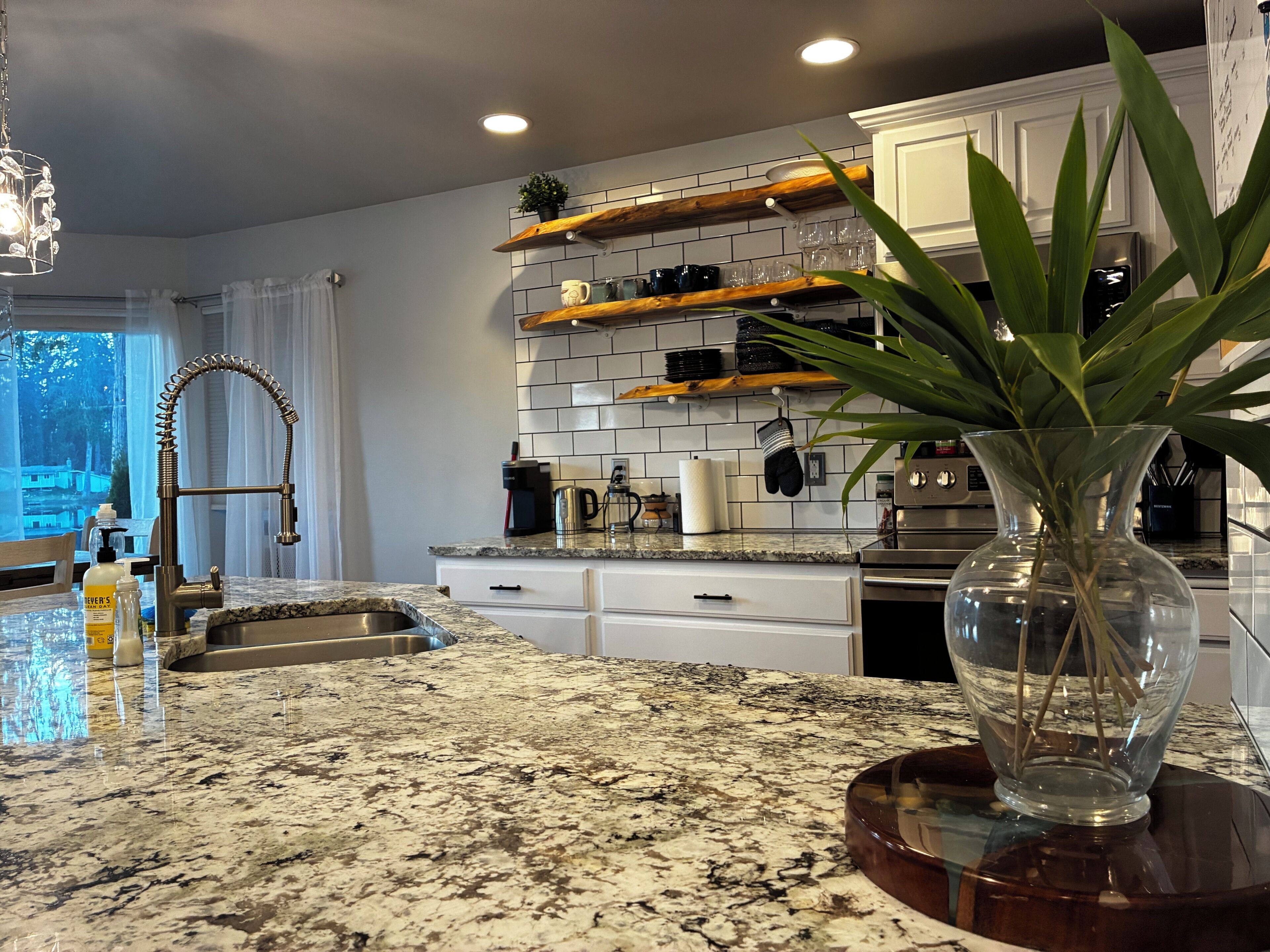 A kitchen with granite countertops, a stainless steel sink, and a built-in oven.