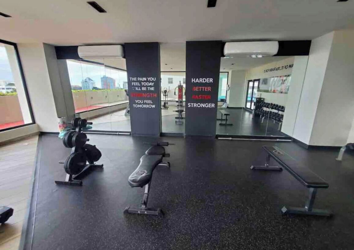 A gym with weightlifting equipment, benches, and motivational quotes on the walls.