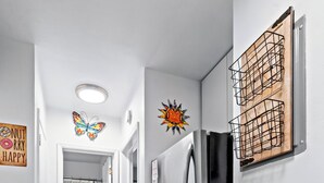 Een keuken met een roestvrijstalen koelkast, een houten snijplank aan de wand, en een vlinderdecoratie.
