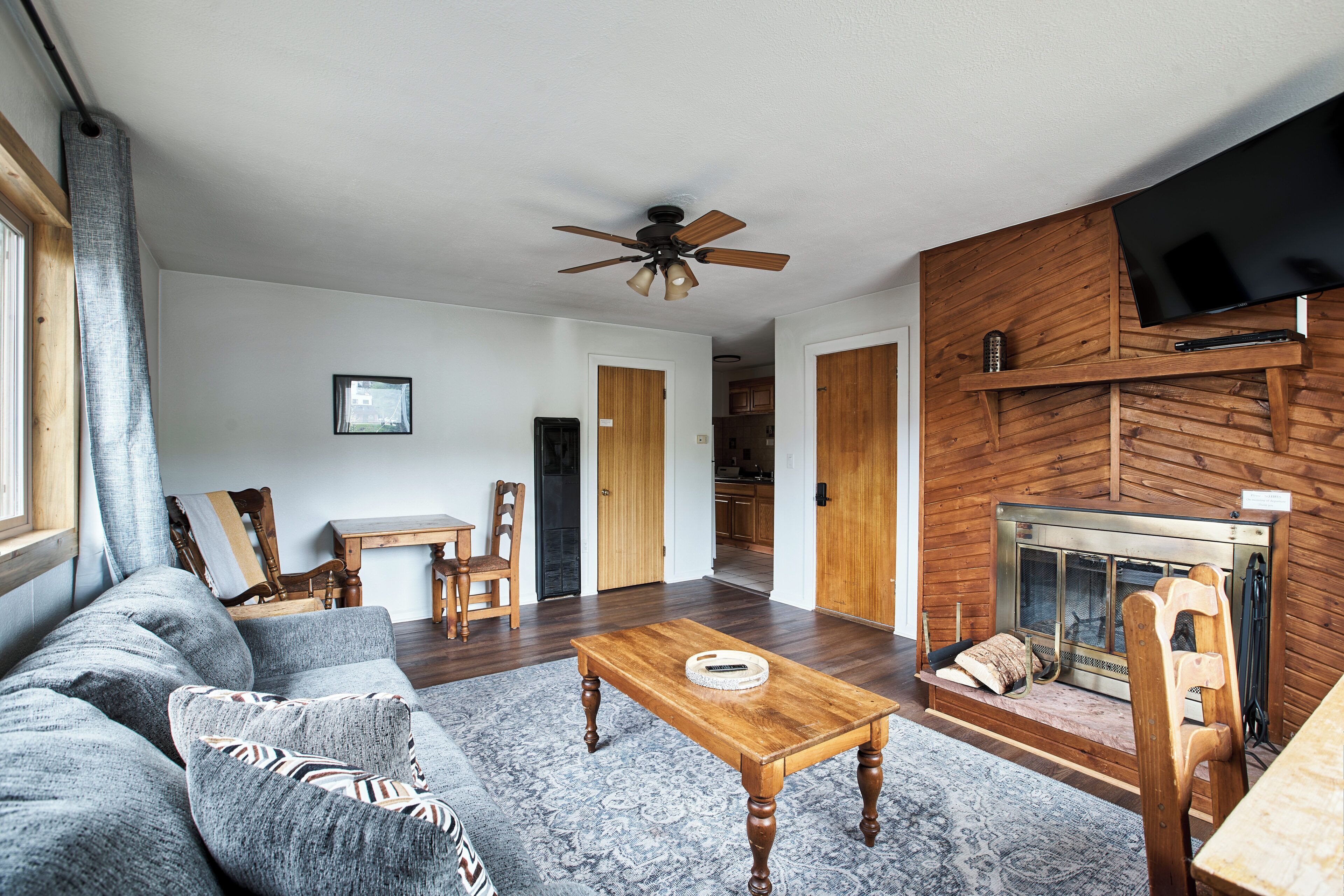 A living room with a sofa, coffee table, fireplace, and TV.
