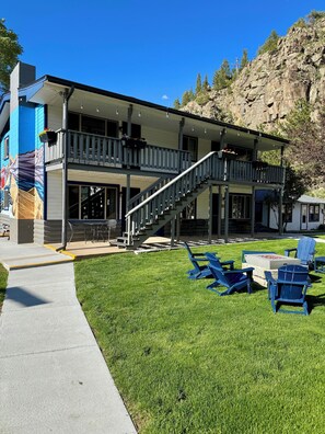 A two-story building with a balcony, outdoor seating, and a staircase leading to the upper level. - Misty Mountain Lodge (Estes Park)