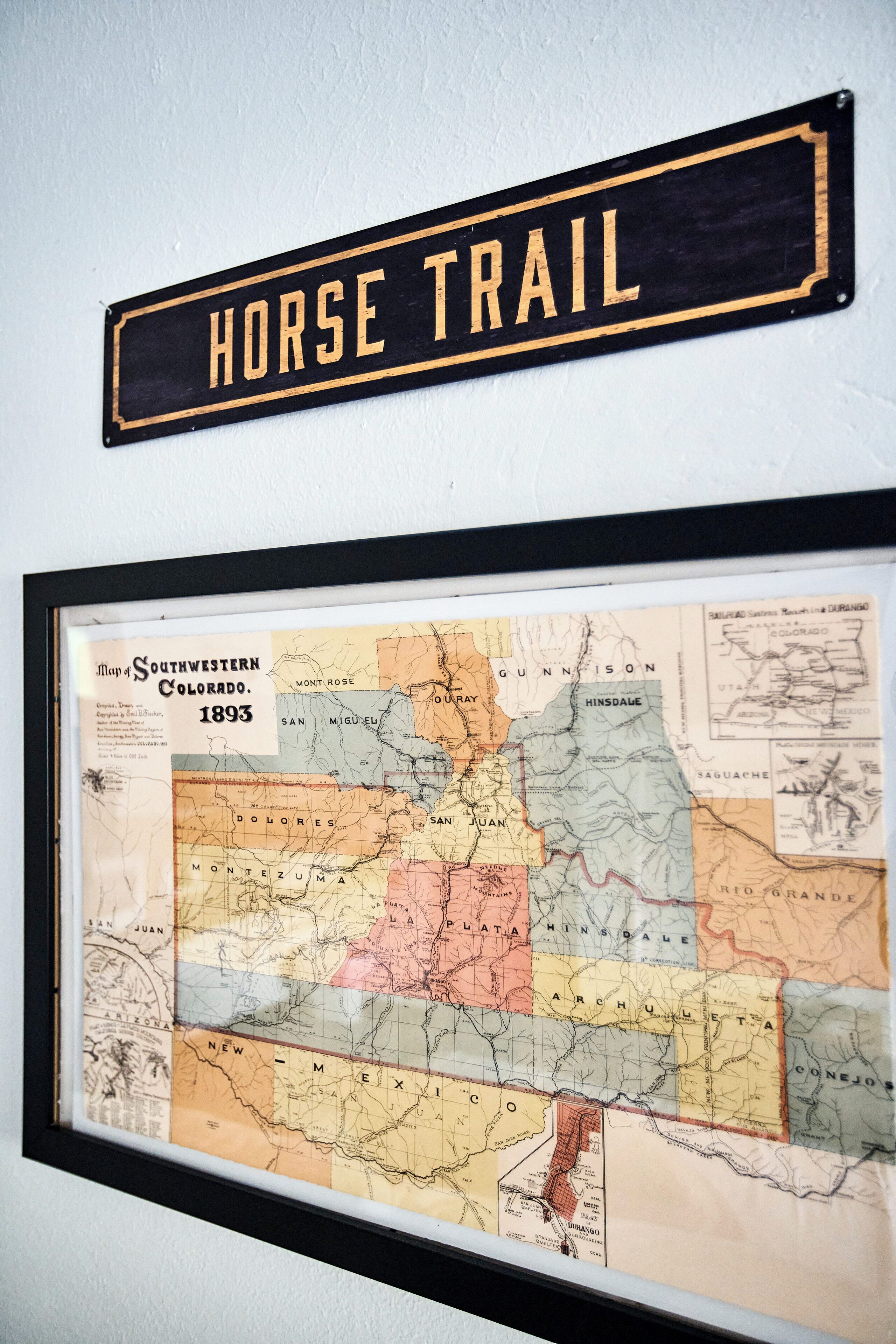 A framed map of Southwestern Colorado from 1893, with a sign above it reading "HORSE TRAIL".