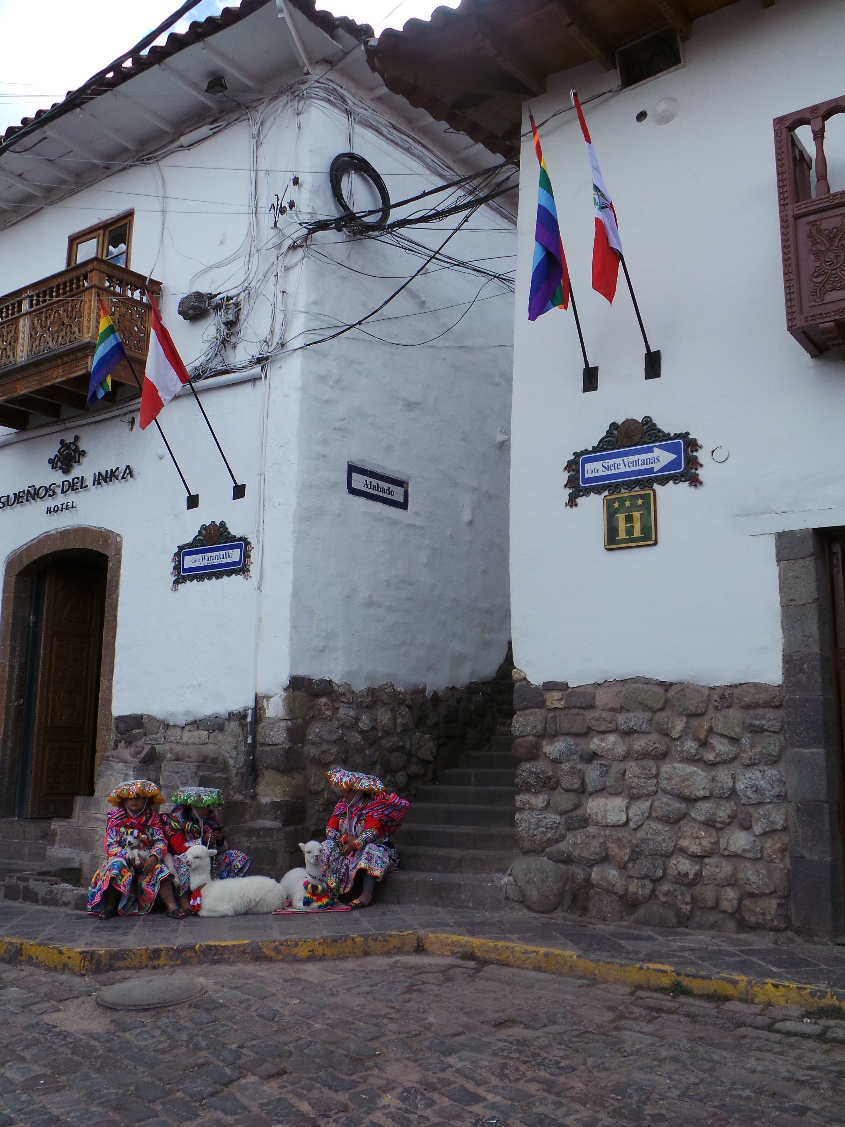 A hotel named 'Sufenos del Inka' with a sign indicating 'Alabado' and 'Calle Siete Ventanas'.
