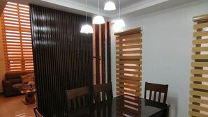 A modern dining area with a glass-top table, wooden chairs, and a bench. - Luxury Solar Home where Style Meets Sustainability (Lipa)