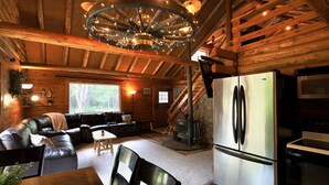 L’intérieur d’une cabane en rondins comprend un salon, un coin repas et une cuisine.