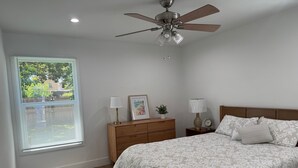 A bedroom with a bed, a nightstand, a ceiling fan, a window with blinds, and a rug. - Beach cottage-5 blocks from the sand. (Port Hueneme)