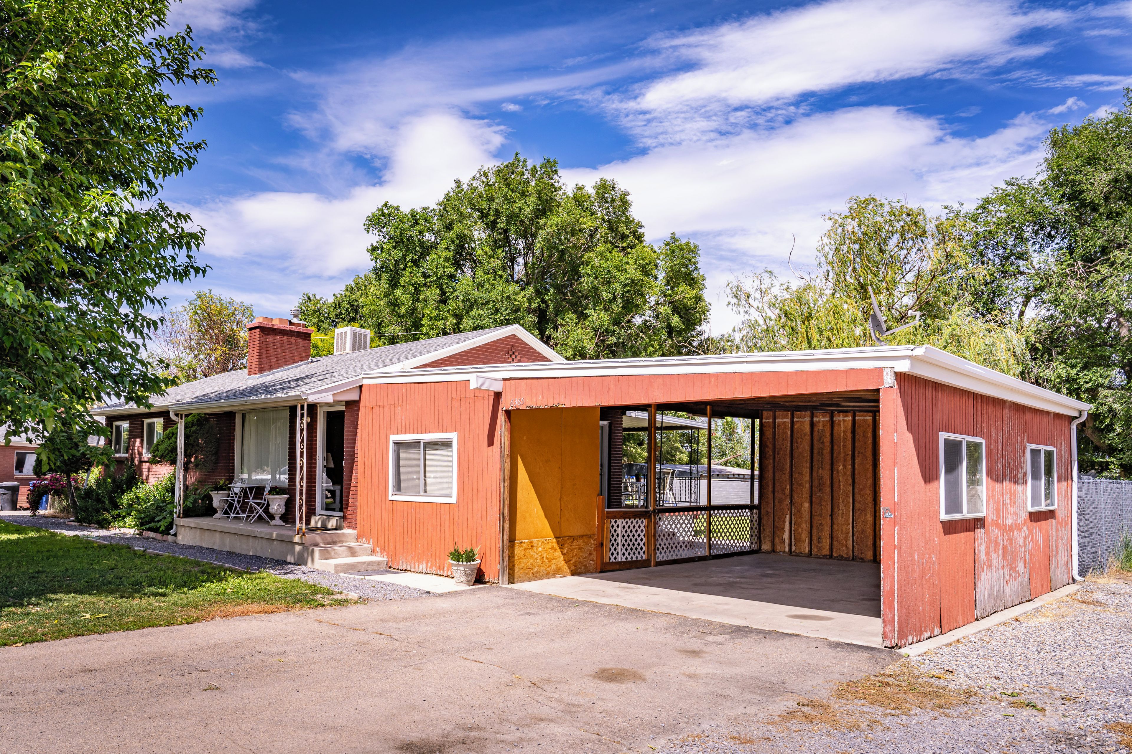 A single-story house with a red exterior, a covered porch, and a garage.