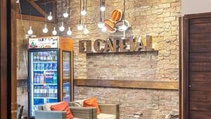 A lobby area with a stone wall, a sign reading "FCAELI", and seating arrangements.