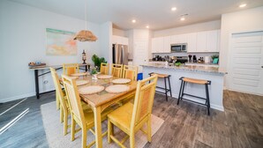 A modern kitchen with white cabinets, stainless steel appliances, and a granite countertop.