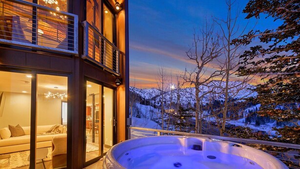A modern building with a hot tub on a balcony overlooking a snowy landscape. - Enjoy pure luxury in Alta in this Contemporary Condominium with Hot Tub (Alta)