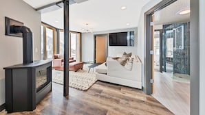 A modern living room with a fireplace, a sofa, and a television. - Enjoy pure luxury in Alta in this Contemporary Condominium with Hot Tub (Alta)