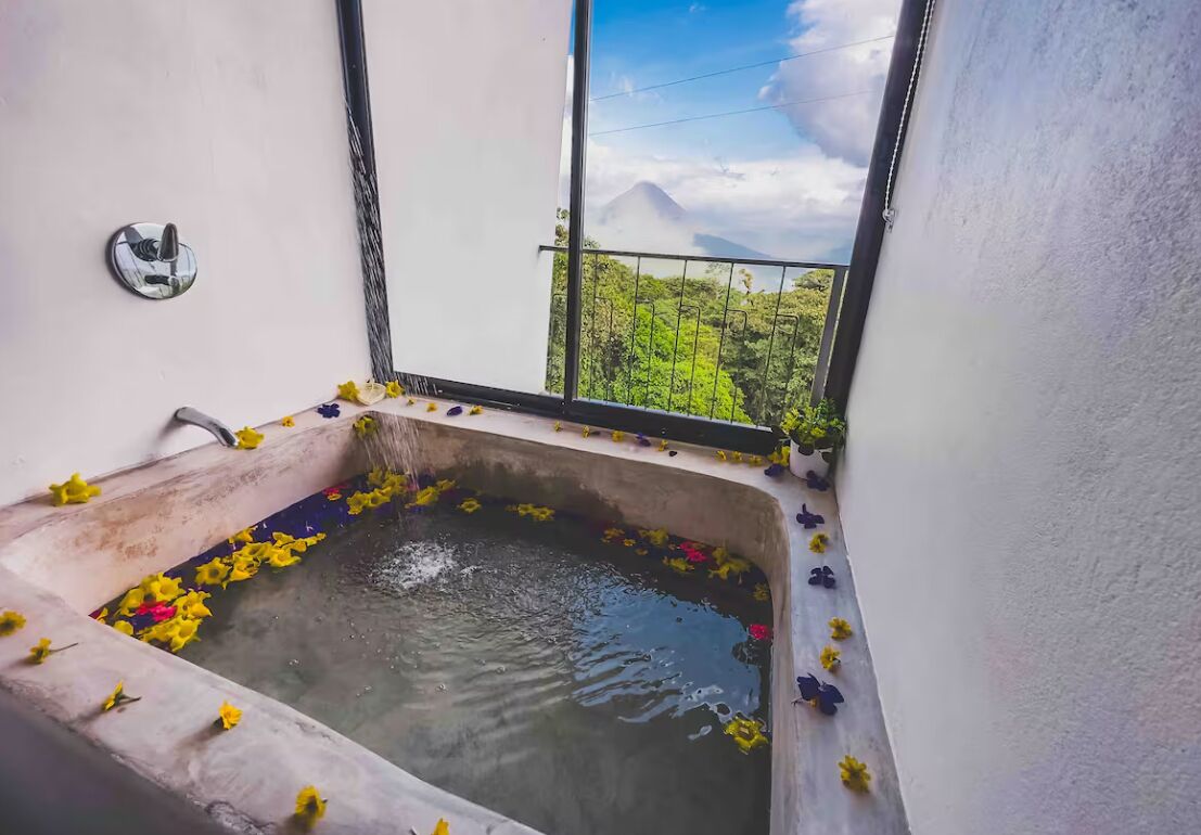 Una vasca da bagno con vista su una montagna e vegetazione.
