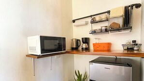 Une petite cuisine équipée d’un four à micro-ondes, d’une machine à café et d’un réfrigérateur Galanz.