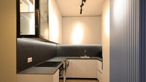 A modern kitchen with a built-in oven, a sink, and a countertop. - Illyrian Apartment 02 (Durrës)