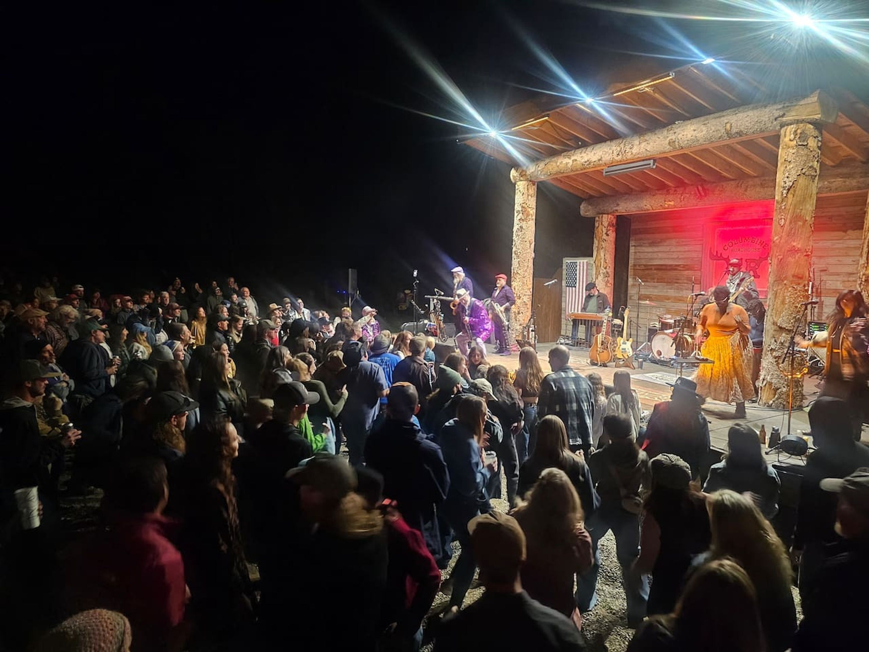 A crowded outdoor event with a stage and audience.
