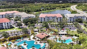 A resort with multiple buildings, a swimming pool, and a lake.