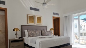 Een slaapkamer met een groot bed, een plafondventilator en uitzicht naar buiten.