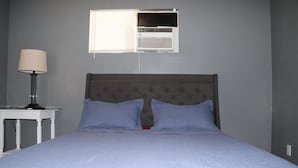 A bedroom with a bed, a nightstand, a lamp, and a window with blinds. - Spacious 2-Bedroom Retreat in San Jacinto; Sleeps 6, AC & Pet-Friendly (San Jacinto)