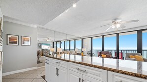 A modern kitchen with white cabinets, granite countertops, and a large island. - BEACH FRONT, FAMILY FRIENDLY, WALK TO THE HANGOUT! | BEACHBALL PROPERTIES (Gulf Shores)