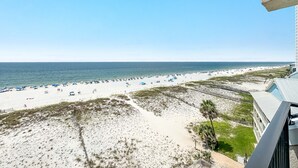 A beach view with a building in the foreground. - BEACH FRONT, FAMILY FRIENDLY, WALK TO THE HANGOUT! | BEACHBALL PROPERTIES (Gulf Shores)