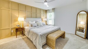 A bedroom with a bed, bedside tables, a mirror, a ceiling fan, and a window with curtains. - ~ 10 Mi to Dallas Hospitals: Stylish Home w/ Yard! (Dallas)