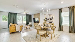 A modern living room with a sofa, coffee table, and dining area with chairs and a table. - ~ 10 Mi to Dallas Hospitals: Stylish Home w/ Yard! (Dallas)