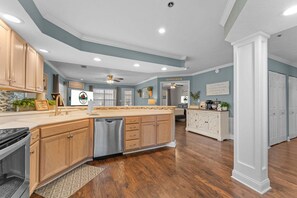 A spacious kitchen with wooden cabinets, a dishwasher, and a large island. - Relaxing Walk-In Condo •Community Pool • Pet Friendly (Branson)