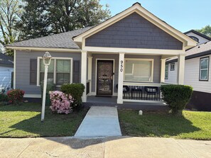 A residential house with a front porch, a mailbox, and a number '950' on the door.